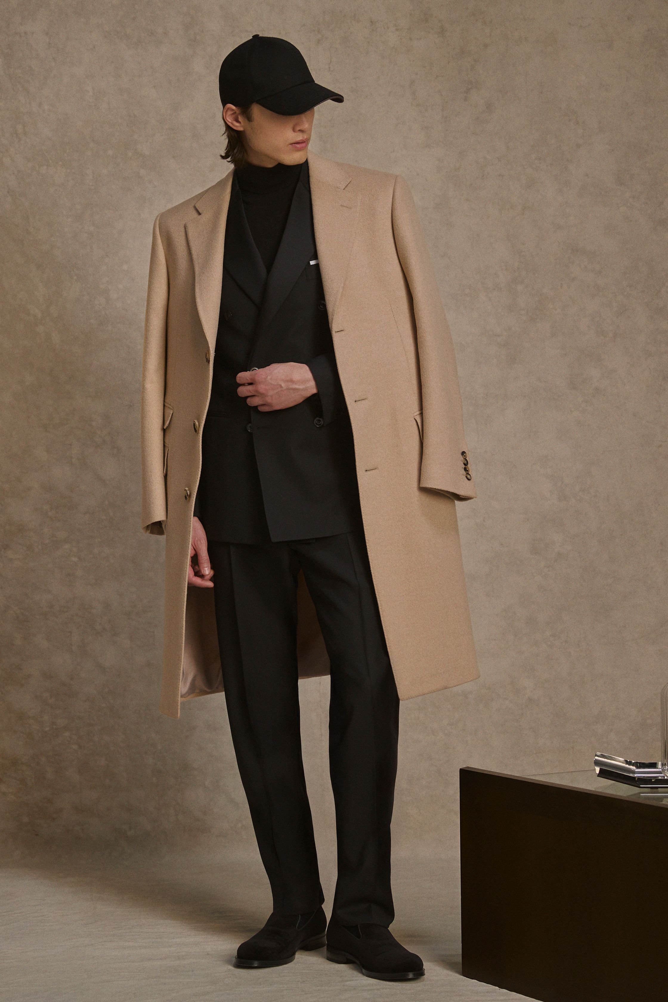 Canali 26FW 继续以“可穿的优雅”定义现代意大利男装。柔软大衣、针织内搭与轻结构西装在暖驼、深棕与午夜蓝中展开，强调城市绅士的实用美学。系列弱化正式与休闲的界限，通过层次与材质完成日常—商务的自然过渡。Canali 并不追逐戏剧化表达，而是以稳定、可信的设计语言，为成熟男性提供长期衣橱解决方案-顽石频道趋势研究